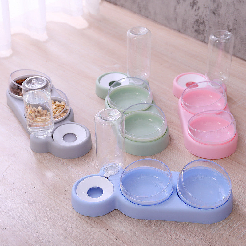 Set of pet feeding and water bowls in various colors on a wooden surface.