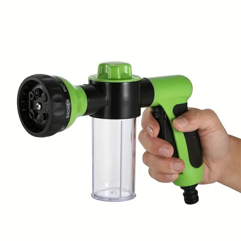 Green and black garden shower head held by a hand on a white background