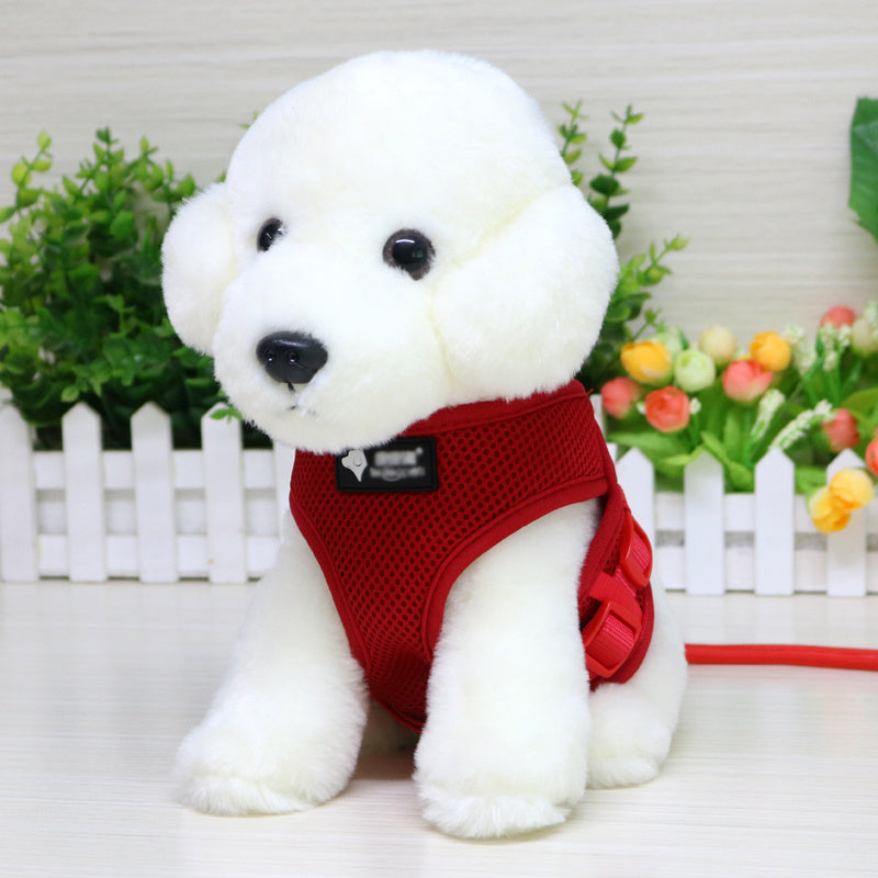 White dog toy with a red harness in front of a white picket fence and flowers.