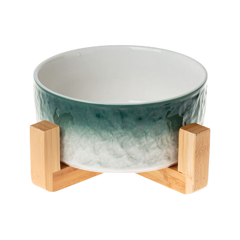 Ceramic bowl with a gradient design on a wooden stand against a white background