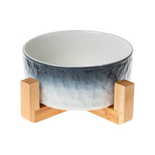 Ceramic bowl with gradient design on a wooden stand against a white background